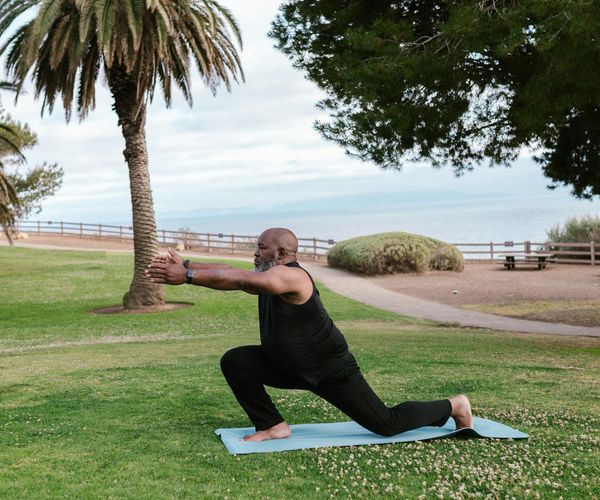 Person stretching on a yoga mat with a serene expression.